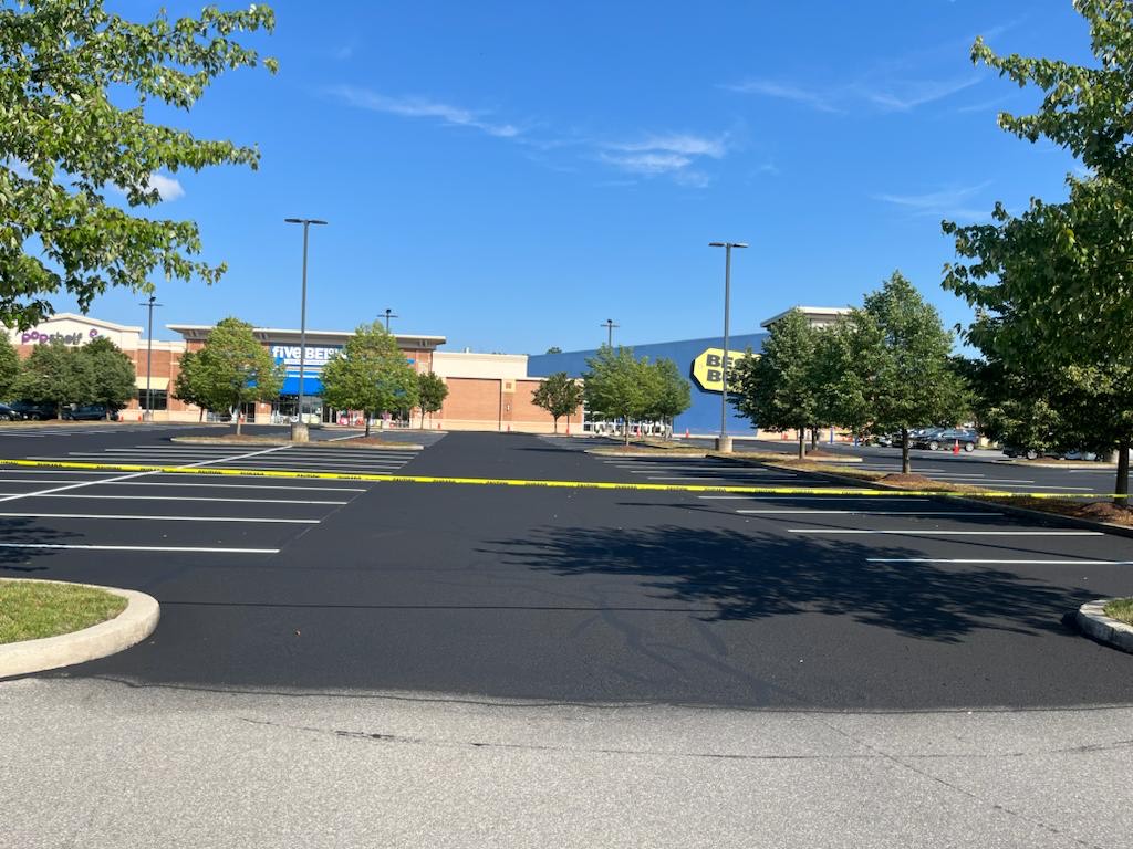 54aa87c7-c181-4199-bf9d-6db21065dd99 A recently sealed and striped parking lot is roped off with caution tape.